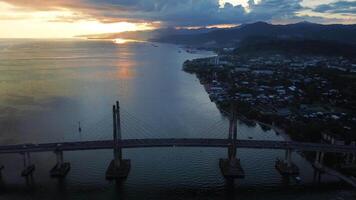 aéreo ver de icónico merah putih cable permaneció puente al otro lado ambon bahía y wai ruhu galala amarillo braguero puente. ambón, Indonesia - abril 6, 2024 video