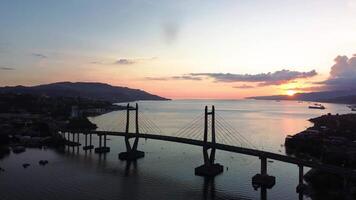 Antenne Aussicht von ikonisch Merah putih Kabel blieb Brücke quer ambon Bucht und wai ruhu galala Gelb Fachwerk Brücke. Ambon, Indonesien - - April 6, 2024 video