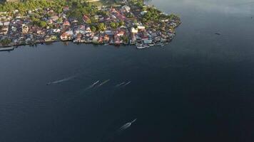 antenne visie van draak boot team roeien naar de tempo van een aan boord trommelaar. maluku, Indonesië, april 12, 2024 video