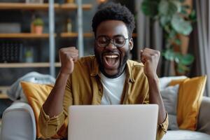 AI generated A joyful African American man is sitting on a comfortable sofa in the living room and is focused on the screen of his laptop. Victory, winning concept photo