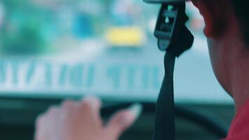 Rear view of a driver in a vehicle with focus on the seat belt and blurred background. video