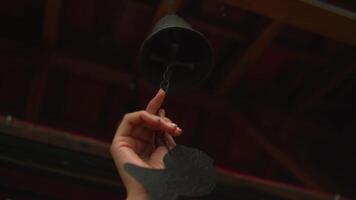 Hand reaching to pull a ceiling fan's cord switch with a dark background. video