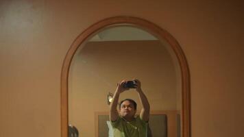 Man taking a selfie in mirror with warm ambient lighting video