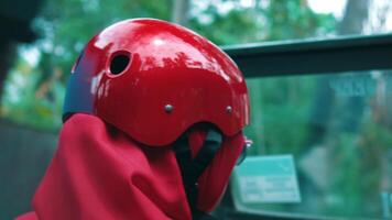 avvicinamento di un' persona nel un' rosso casco e sciarpa, con un' sfocato sfondo suggerendo movimento o viaggio. video