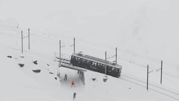 zermatt, schweiz - de tåg av gonergratbahn löpning till de gornergrat station i de känd turistiska plats med klar se till matter under en tung snö storm. video