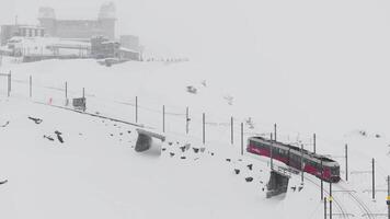 Zermatt, Svizzera - il treno di gonergratbahn in esecuzione per il gornergrat stazione nel il famoso turistico posto con chiaro Visualizza per Cervino durante un' pesante neve tempesta. video