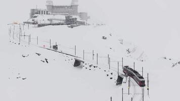 zermatt, schweiz - de tåg av gonergratbahn löpning till de gornergrat station i de känd turistiska plats med klar se till matter under en tung snö storm. video