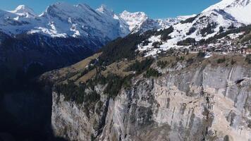 hermosa panorámico aéreo ver de el Murren esquí recurso pueblo en Suiza. lujo hoteles y edificios situado en el borde de el acantilado. video