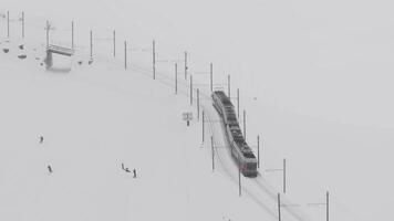 zermatt, Suiza - el tren de gonergratbahn corriendo a el gornergrat estación en el famoso turístico sitio con claro ver a materia durante un pesado nieve tormenta. video