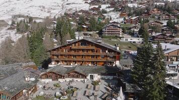 Aerial panoramic view of the Verbier ski resort town in Switzerland. Classic wooden chalet houses standing in front of the mountains. video