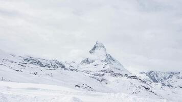 Scenic view on snowy Matterhorn peak in sunny day with blue sky and some clouds in background, Switzerland. video