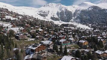 aéreo panorámico ver de el Verbier esquí recurso pueblo en Suiza. clásico de madera chalet casas en pie en frente de el montañas. video