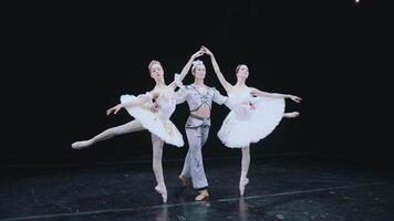 A ballet dancer, a man and two ballerinas pose on stage. Bayadere. Classical ballet Beautiful ballet position. Frame shot on steadicam video