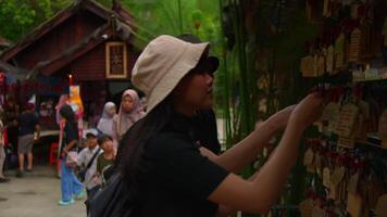 Two young adults exploring, wearing casual clothes and hats, with lush greenery in the background. video