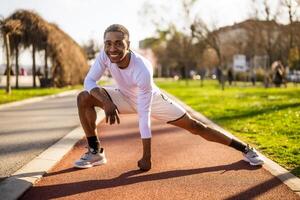 joven afroamericano hombre es hacer ejercicio en el ciudad. él es extensión su cuerpo. foto