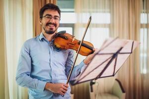 hombre jugando violín a hogar. él es practicando para En Vivo actuación. foto