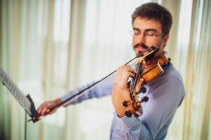 hombre jugando violín a hogar. él es limpieza su instrumento. foto