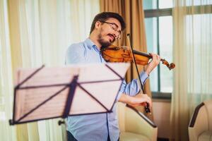 hombre jugando violín a hogar. él es limpieza su instrumento. foto