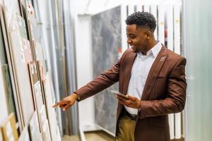 Portrait of buyer in bathroom store. Man is choosing tiles for his apartment. photo