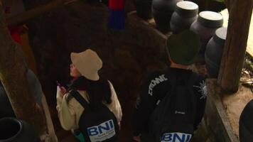 Two people from behind watching an event while walking on the the stairs, wearing hats video