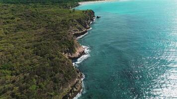 Antenne Aussicht von beschwingt Wasser Ozean erstellen entlang felsig und malerisch Küste, mit Wellen abstürzen gegen Felsen. diese tropisch Insel ist umgeben durch Türkis Gewässer. fliegen nach vorne video