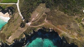 aéreo ver de orilla rocas besado por turquesa ondas, su salpicaduras haciendo eco con cada descanso. vuelo desde el objeto. caribe mar. dominicano república, macao video