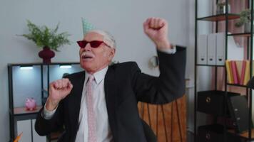 feliz Senior o negócio homem dançando vitória dança a comemorar final de semana feriado sucesso ganhar dentro escritório video