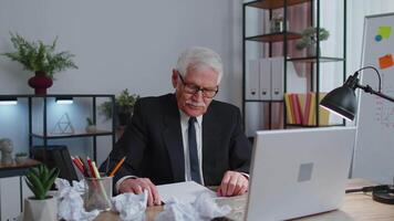 Senior business office man use laptop throwing crumpled paper, having nervous breakdown at work video