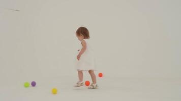 Toddler girl wearing diaper and her sister playing with balls video