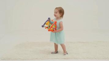 Happy little girl in mint dress is playing toys video