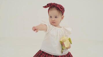 Little girl in plaid headband is eating banana video