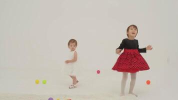 niñito niña vistiendo pañal y su hermana jugando con pelotas video