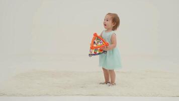 Happy little girl in mint dress is playing toys video