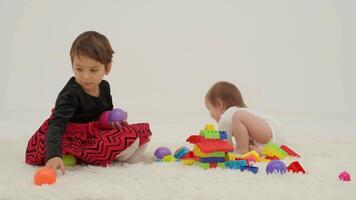 criança pequena menina vestindo fralda e dela irmã jogando com bolas video