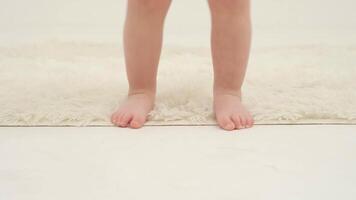 Little girl feet on the white carpet close-up video