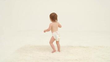 Happy little girl in diaper is dancing video