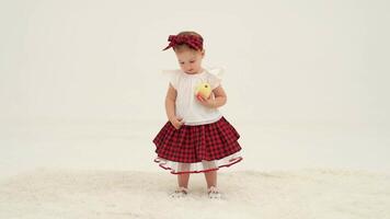 Little girl in plaid headband is holding apple video