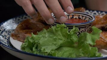 the cook pours sauce on a whole grilled chicken served on a platter video