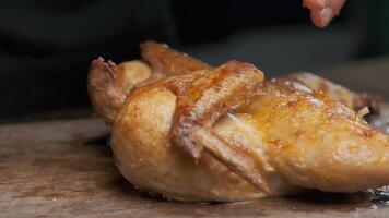 the cook takes the grilled chicken, close up video