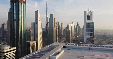 un' fuco mosche al di sopra di il tetto di un' grattacielo con un' eliporto nel dubai, emirati arabi uniti. video