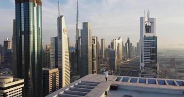 A young man walks on the roof of a skyscraper with a helipad video