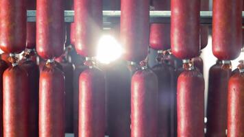 iluminado pelo sol salsichas cura dentro uma fumeiro, luz solar filtros através linhas do vermelho salsichas cura dentro uma fumeiro, enfatizando a textura e cor. video