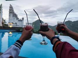 three glasses toasting each other behind the beautiful mountain views photo