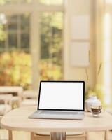 A laptop computer mockup and a coffee cup are placed on a wooden table in a beautiful coffee shop. photo