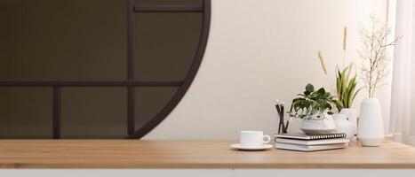 A minimalist wooden table with a space for display products against a white wall with a round window. photo