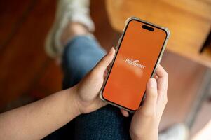 payoneer logo en un iphone14 pantalla, un mujer utilizando el payoneer solicitud en su teléfono inteligente foto