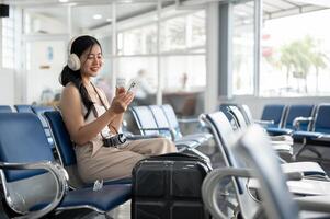 un hembra pasajero sentado a un esperando asiento en el aeropuerto Terminal, esperando para su embarque llamar. foto