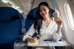 A beautiful Asian businesswoman seated at a window seat on a plane, traveling for a business trip. photo