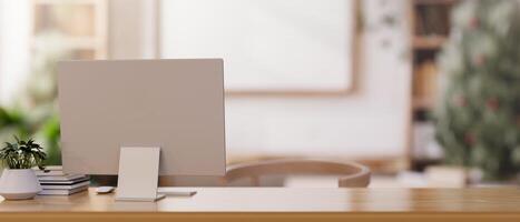 A back view image of a computer on a wooden desk in a minimalist neutral wood living room or office. photo