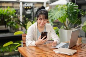 un mujer es utilizando un móvil bancario aplicación en su teléfono inteligente, pago cuentas en línea o comprando en línea cosa. foto